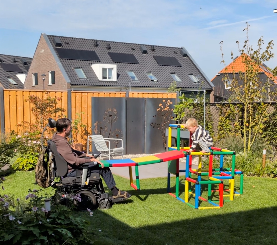 Tuur rent over de glijbaanbrug naar mijn rolstoel
